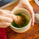 Whisking matcha with bamboo whisk